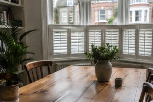 Cafe style shutters fitted to the lower half of a street-facing dining room window